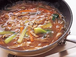 ごま油で表面を焼きつけた中華麺が、カリッとこうばしい。オイスターソースで味つけした、豚肉、あさり、野菜入りのボリュームたっぷりのあんをかけてどうぞ。