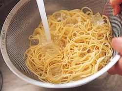 スパゲッティはアルデンテではなく、長めにゆでる。こうすると、流水に当てた時に麺が水分を吸って水っぽくなるのを防げる。水にさらすとどんどんうまみが逃げてしまうので、氷と一緒に流水で一気に冷やす。