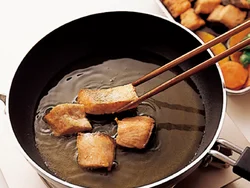 野菜を揚げたら、続けて鮭を揚げる。南蛮だれに漬けて、味がなじんだらでき上がり。