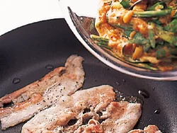 フライパンに豚肉を並べて、色が変わってきたところに生地を流す。薄く、全体に広げるのがコツ。