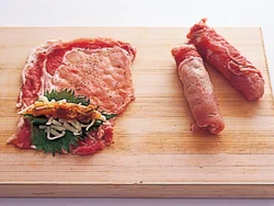 具が端からはみ出ないように、途中で、豚肉の両端を内側に折り込んで巻く。
