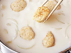 ホワイトソースは、バターで炒めた玉ねぎに小麦粉をふって炒め、牛乳を加えて作るので、簡単＆失敗なし。ここに、焼いておいた肉だんごを戻し入れる。