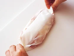 豚肉とホールトマト、チーズを重ねてオーブン用ペーパーに包む。帰った人から、食べる分だけ焼くことができるので、便利。