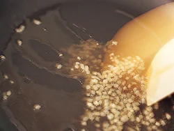 にんにくも韓国料理に欠かせない素材の一つ。ごま油ににんにくの風味を移すようにじっくりと炒めてから、ごぼうを加える。ごぼうにもにんにくの風味をきかせる。