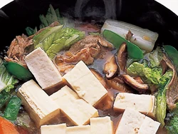 肉、野菜を炒めたところに、干ししいたけのもどし汁や調味料を加えたら、豆腐を入れ、少し煮てうまみを含ませる。