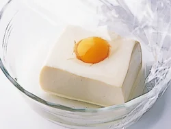うずらの卵をのせた豆腐を電子レンジ加熱するときは、かけたラップが卵につかないように、豆腐より深さのある耐熱容器を使う。