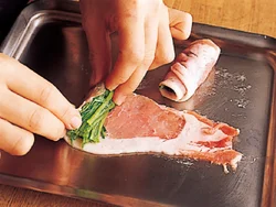 肉を広げ、手前にゆでたほうれん草をたっぷりのせて、内側にくるくると巻く。