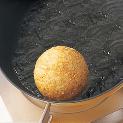 フライパンの中でおにぎりを転がしながら焼き色をつけ、カリカリ感を出す。
