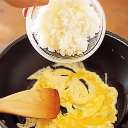 卵とご飯がなじむように、卵が半熟状になったところに手早くご飯を入れる。