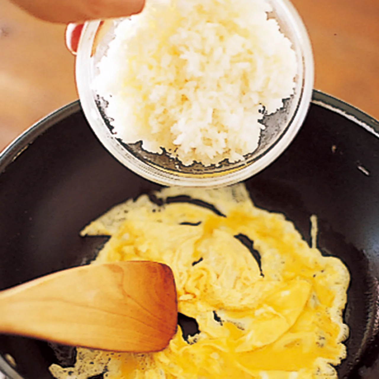 卵とご飯がなじむように、卵が半熟状になったところに手早くご飯を入れる。