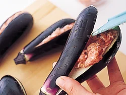 なすは横半分に切り込みを入れ、肉だねを詰める。なすのへたは残して詰めるので、肉だねが安定して詰められる。