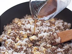 黒酢を入れた合わせ調味料を加えると、ご飯がよくほぐれて炒めやすくなり、全体に黒酢のうまみがいきわたって味つけが簡単になる。