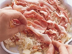 生地代わりのじゃがいも、玉ねぎを広げ、ソースをぬった上にこま切れ肉を広げる。