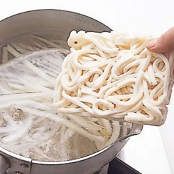 一緒にゆで上げるため、白菜の軸、うどん、葉の順に入れていく。