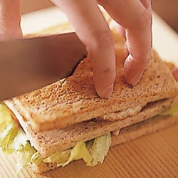 何層にも重ねたサンドイッチは片手で軽く押さえて、包丁を前後に動かしながら切るとよい。