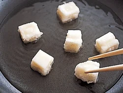 もちは、少なめの揚げ油で、転がしながら揚げ、表面がぷくっとふくらんだら取り出す。
