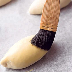 焼きピロシキは表面に溶き卵をぬってから焼く。こうすると、こんがりとつやのある、おいしそうな焼き上がりに。