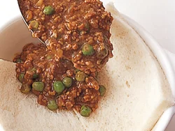 器に合わせて食パンを敷き、その上にカレーをのせる。パンは少し飛び出させると、カリッと焼けておいしい。