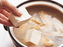 手羽先をじっくり煮てうまみが出たところに豆腐を入れ、スープを吸わせる。