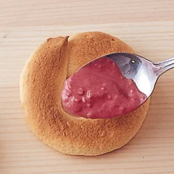 溶かしたいちごチョコレートに、砕いたコーンフレークを混ぜ、ドーナッツの表面にまんべんなくのせる。