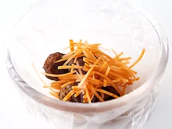 ボウルに凍ったままの肉だんごと、にんじんをせん切りにして入れてレンジで加熱すれば、野菜も一緒のおかずに。