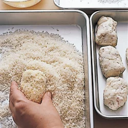 ころもづけは、小麦粉とパン粉をつける手と、溶き卵をつける手を使い分けると、手際よく作業できる。パン粉をつけたら、パン粉の上で転がすようにするときれいな俵形に整う。