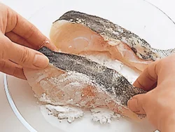 たらは塩、こしょうをふってから片栗粉をまぶし、水分が出るのを防ぐ。