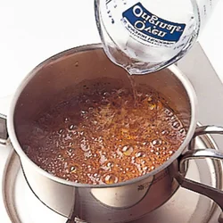 グラニュー糖と水を入れて火にかけ、このくらい茶色くなったら湯を入れてのばす。はねることがあるので注意する。