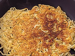 中華蒸し麺は、表面をこんがり焼くと、食べごたえがアップ。よくほぐして油を熱したフライパンに入れて。