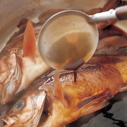 少ない煮汁を魚にかけながら煮る