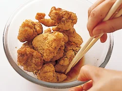 揚げたとり肉に甘酢をからめて味をしみこませる。