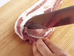 豚肉は肉と脂身の間にところどころ切り目を入れ、加熱したときに肉が反るのを防ぐ。