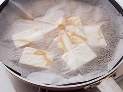 落としぶたをして煮ると、煮汁が少なくても、全体に煮汁がまわって、豆腐に味がしみこみやすくなる。