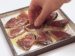 塩、こしょうのあとにオリーブ油をかけ、指で軽く表面をたたいて味をなじませる。