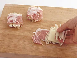 広げた肉にじゃがいもをのせてチーズをのせ、さらにじゃがいもをのせる。豚肉は左右をたたむようにして重ねる。