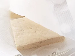 豆腐の水きりは、電子レンジ加熱で手軽に。厚みを半分に切った豆腐を、ペーパータオルではさんで加熱する。