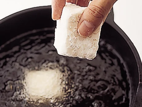 油がはねないように、豆腐にしっかり片栗粉をまぶし、軽くはたいて余分な粉を落としてから、油に入れる。