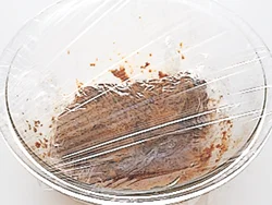 肉に味がなじみやすいようにラップで落としぶたをし、肉がパサつかないようにさらにラップをかけて蒸らす。
