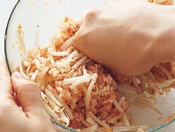 もやしは手で握って折りながら混ぜると、自然に細かくなってひき肉に混ざりやすくなる。