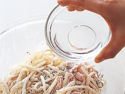 もやしと塩昆布、豚肉に小麦粉と片栗粉がよくなじんでから、水を加えて混ぜる。