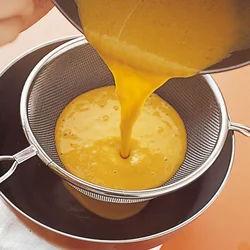 ざるで裏ごしするとプリン液がなめらかになる。