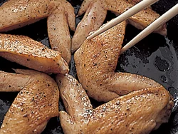 手羽先はフライパンでこんがり焼き色がつくまで焼くとこうばしく仕上がる。骨に沿って切り目を入れると火の通りも早い。