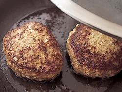 ハンバーグは表面が色づくまで焼いてから、ふたをして蒸し焼きにすると、こうばしく、ふっくら。この段階では、中まで完全に火が通らなくてよい。