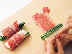 牛肉を広げ、手前に長いも、万能ねぎを置いてくるくる巻く。巻き終わりを焼きつけて固めるので、ようじなどで留めなくてもよい。