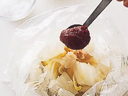 塩もみした白菜を水けを絞ってポリ袋に戻し、さらに調味料を加えてしっかりともむ。