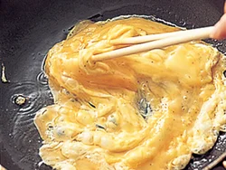 多めの油に入れて手早く混ぜ、ふわっとした半熟状に仕上げる。