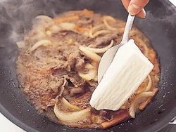 豆腐はスプーンで大きくすくって加えると、表面に凹凸ができて、煮汁がからみやすい。