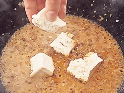 煮汁がからみやすいように、豆腐は一口大にちぎって加える。ごまは、風味がとばないようにあとから加えて。