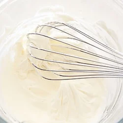 生クリームとクリームチーズを混ぜ、泡立て器で線が書けるくらいのかたさまで泡立てる。