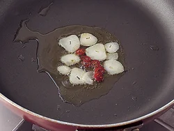 弱火でじっくり熱し、にんにく、赤とうがらしの風味をオリーブ油に移してから、ほかの食材を炒める。